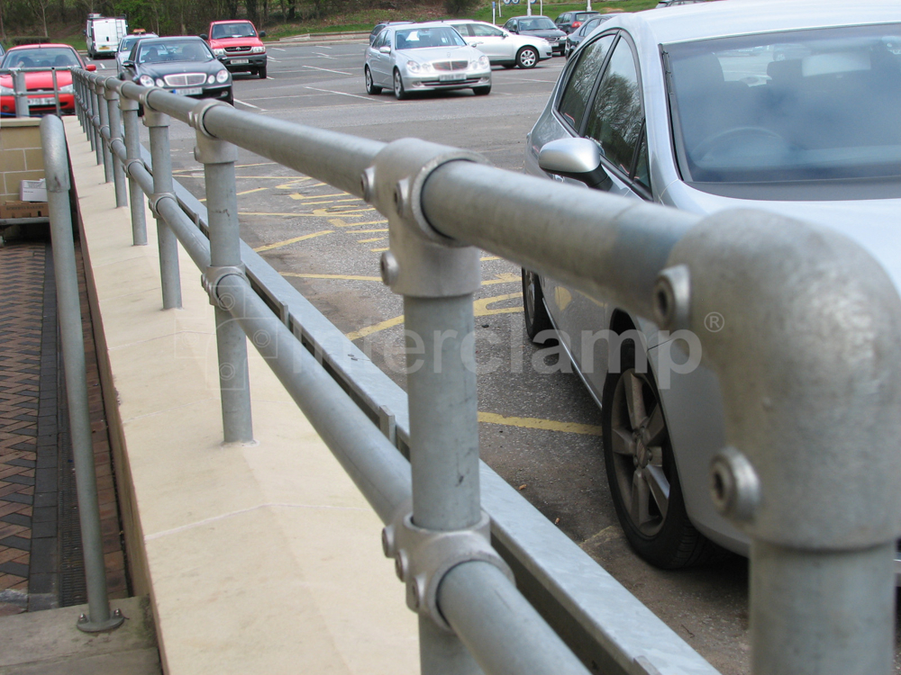 galvanised key clamp guardrail constructed on top of a concrete wall at a service station